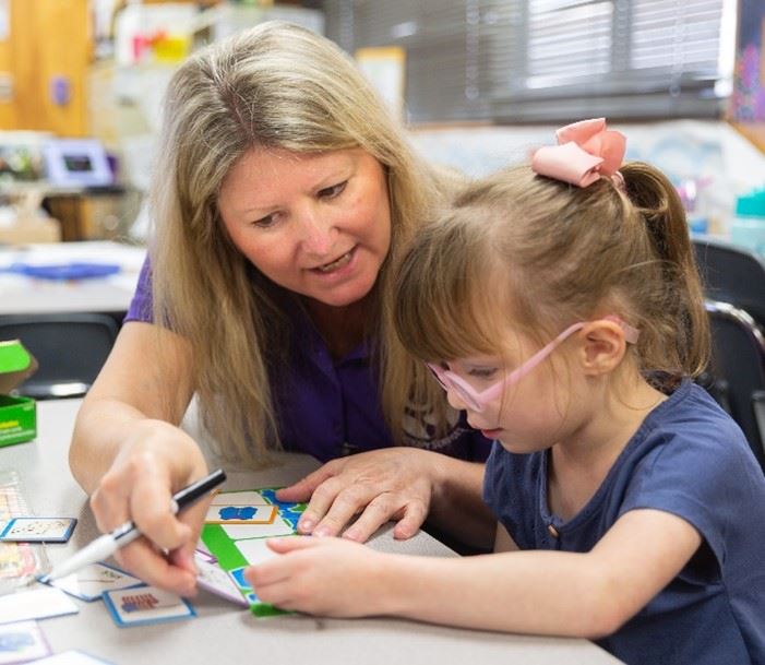 Therapist helping girl with printing